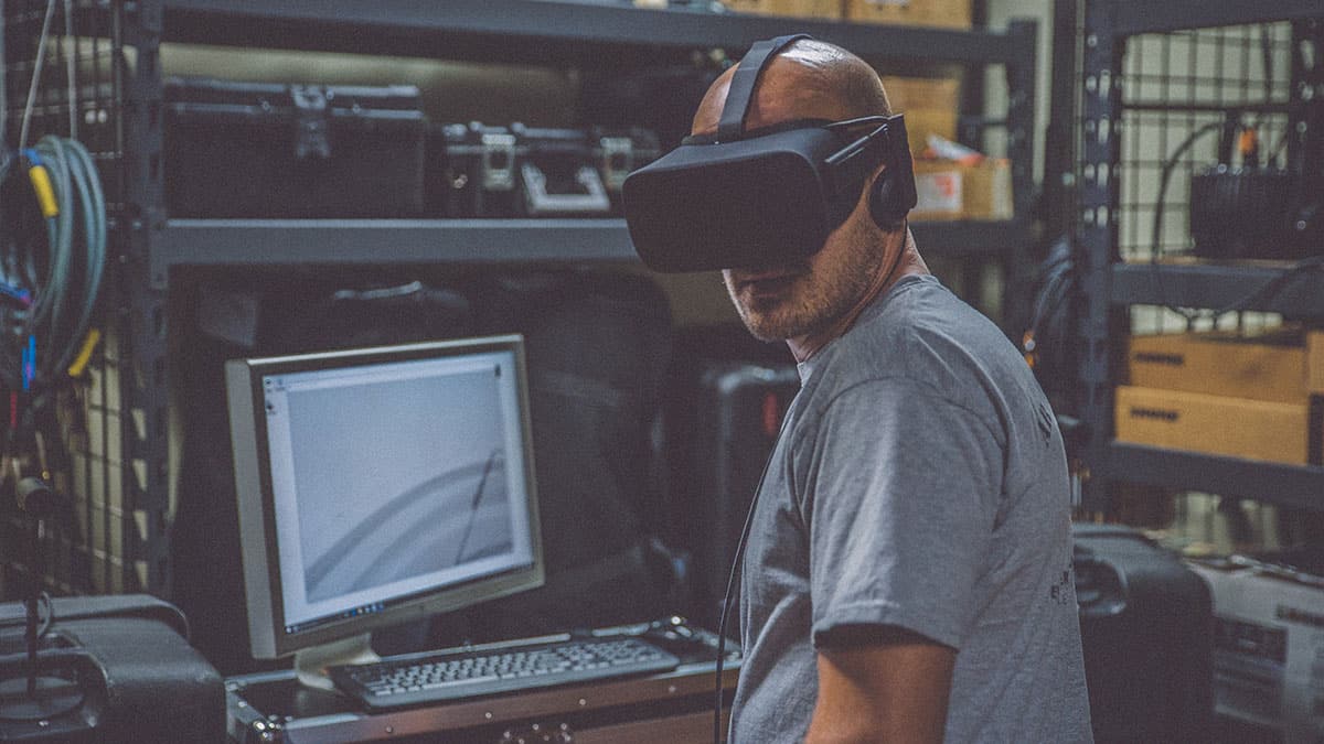 Technician wearing a VR mask while working on a computer. 