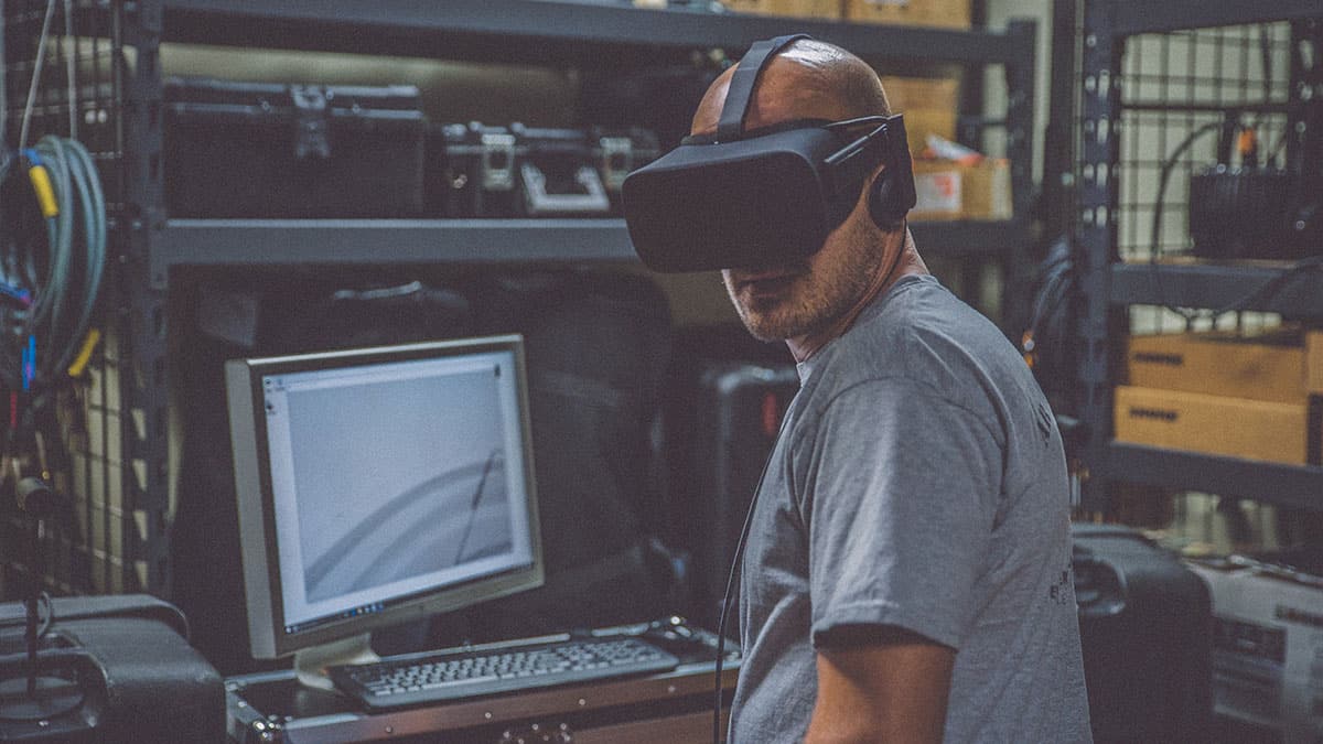 Technician wearing a VR mask while working on a computer.